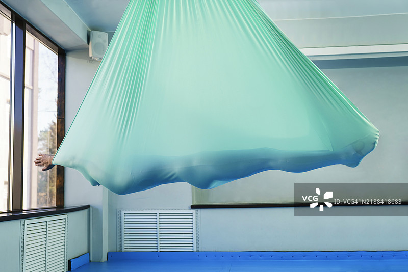 女人在吊床上做瑜伽，保持水平悬挂的平衡与专注图片素材