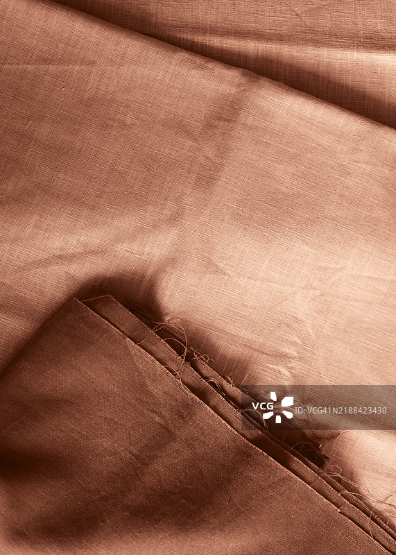 柔和光线下的光滑和有纹理的自然棕色面料。展示2025年流行色摩卡慕斯。图片素材