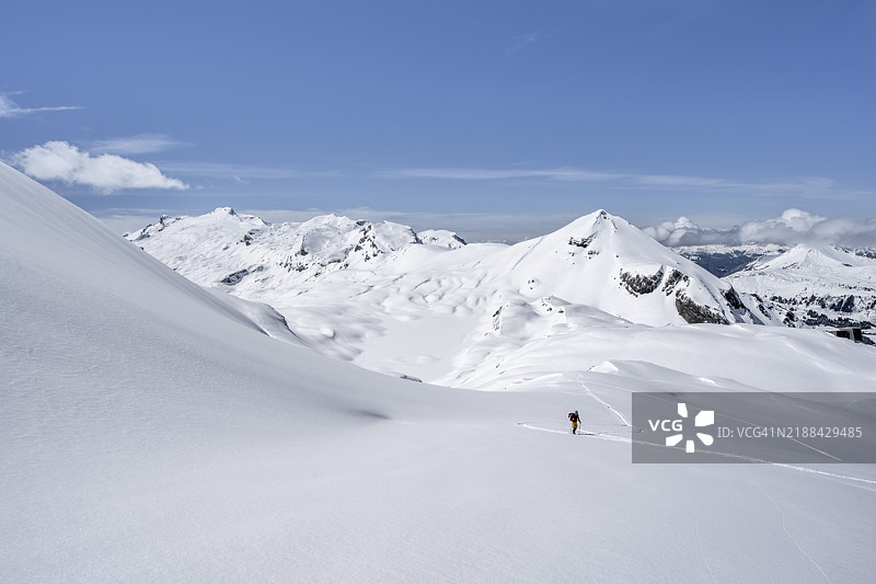 孤独的滑雪旅行者在雪山风景中，米塔霍恩峰和维尔德霍恩峰的顶峰，攀登到维尔德斯特鲁贝尔小屋，伯尔尼阿尔卑斯山，瑞士，欧洲图片素材