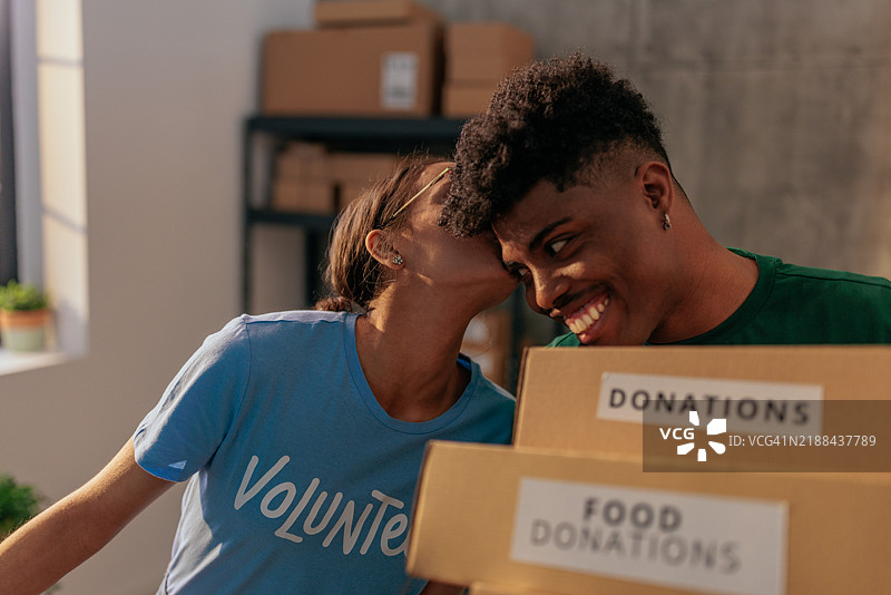 志愿者在搬运捐赠箱时亲吻图片素材