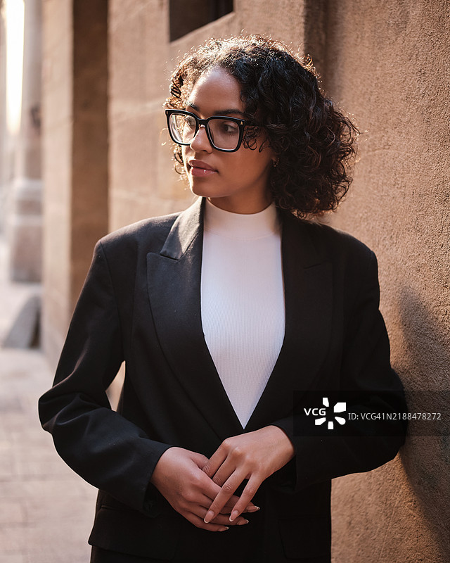 年轻女商人在巴塞罗那靠着墙壁。图片素材