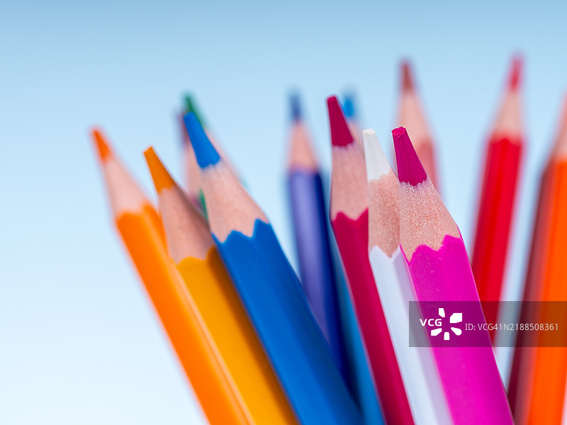 彩色铅笔指向上方，背景为浅蓝色图片素材