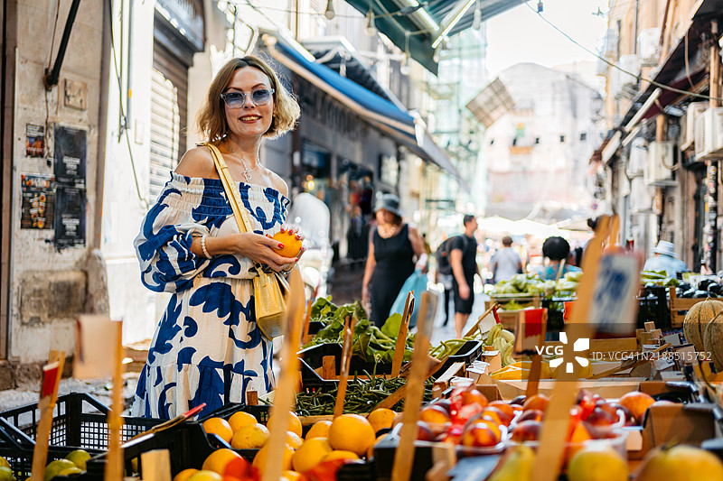 中年女性在意大利巴勒莫的街市上购买橙子图片素材