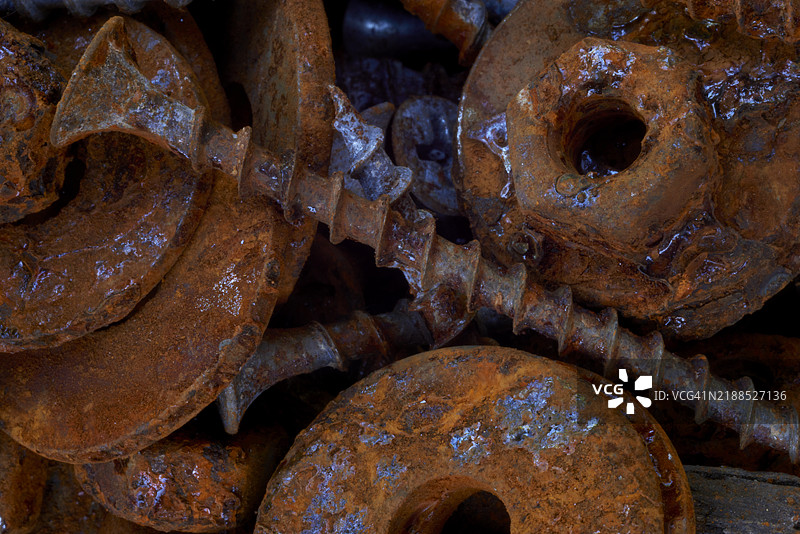 生锈的螺丝、螺母和垫圈构成抽象的工业背景图片素材