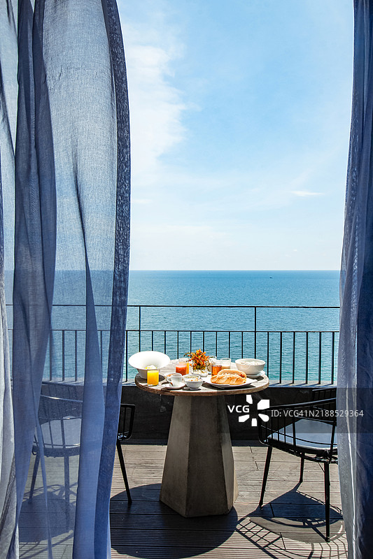 阳台上的双人早餐桌，俯瞰海洋美景图片素材