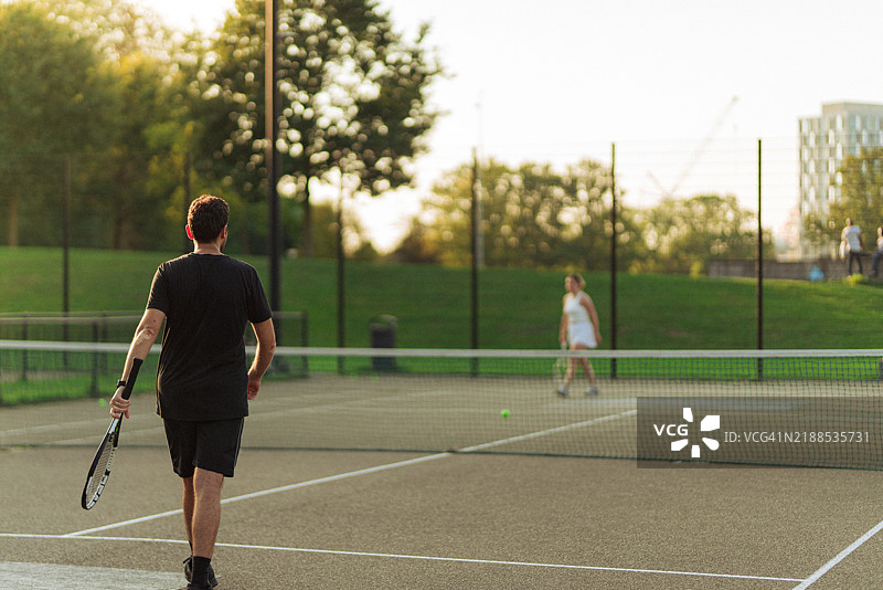 两个人在阳光明媚的日子里打网球图片素材