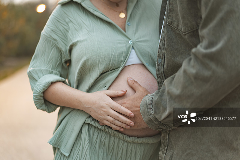 男人的手放在孕妇的肚子上图片素材