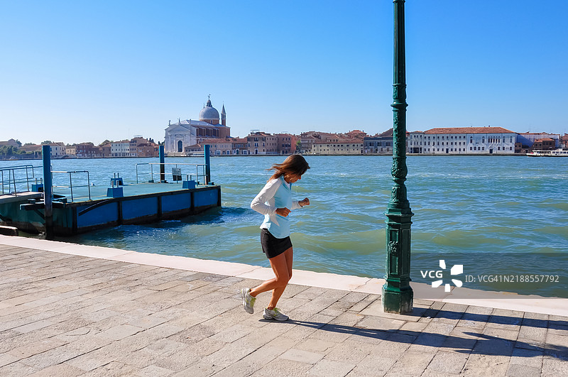 一位年轻女性在威尼斯奔跑图片素材