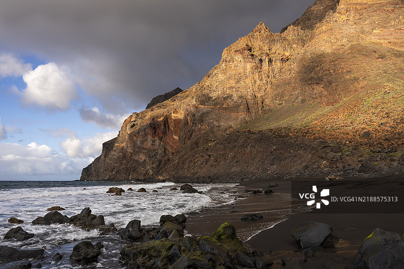 海滩上的阳光和云朵。英格莱斯海滩和拉梅里卡山脉。格兰雷谷,拉戈梅拉,西班牙,加那利群岛,欧洲图片素材