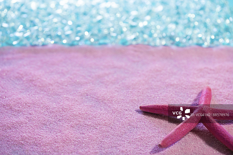 粉色沙滩上的海星与热带海洋的碧蓝水域图片素材