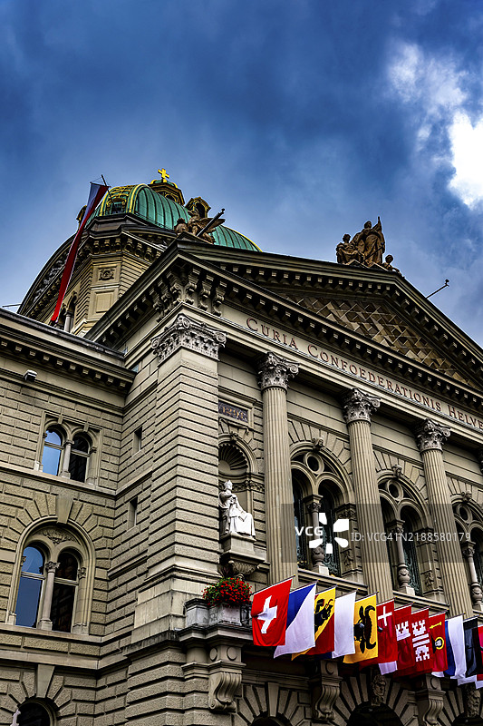 美丽的联邦宫或国会大厦，悬挂着国庆日的州旗，背景是伯尔尼市的暴风云，瑞士，欧洲图片素材