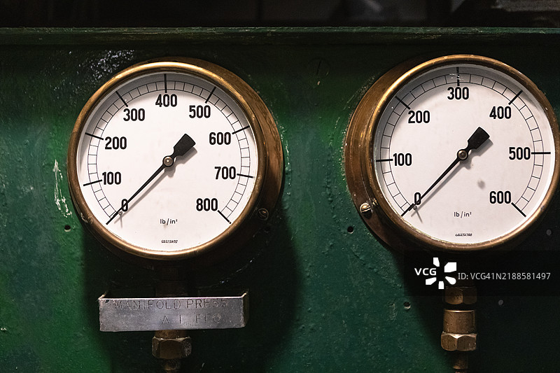 绿色墙壁上的黄铜管压力表图片素材