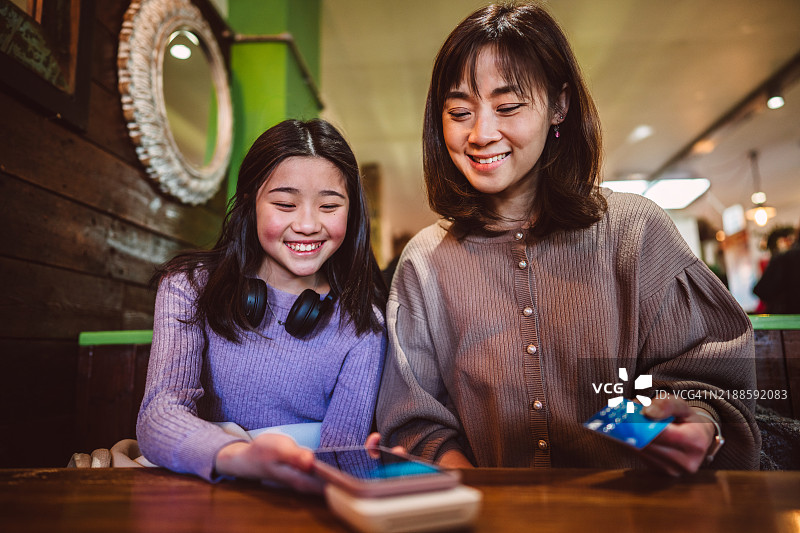 母女在咖啡馆使用非接触式支付图片素材
