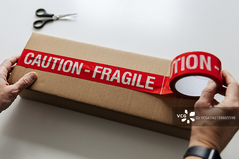 男人在用胶带封装纸箱图片素材