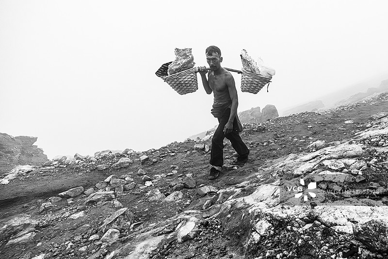 一名硫矿工在印度尼西亚爪哇岛的伊真火山上搬运原硫。图片素材