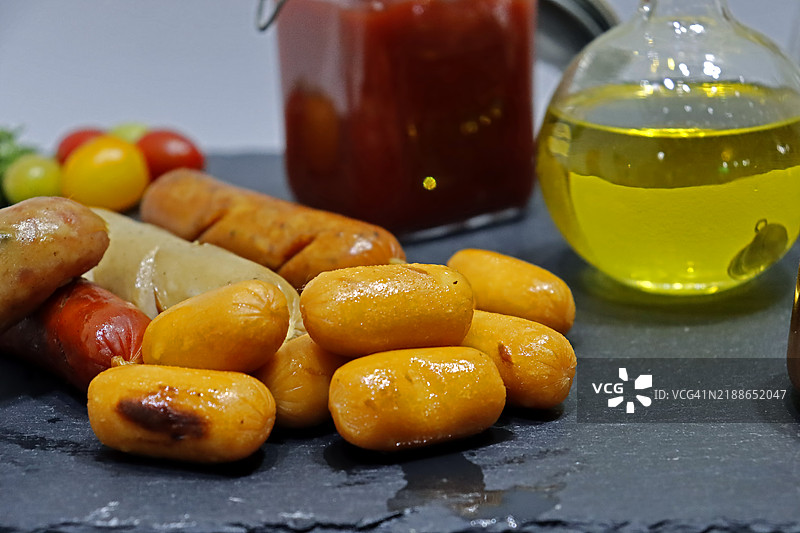 桌子上摆放着多种香肠和各种酱料。图片素材