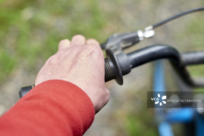 骑自行车时，骑行者用手握住车把。图片素材