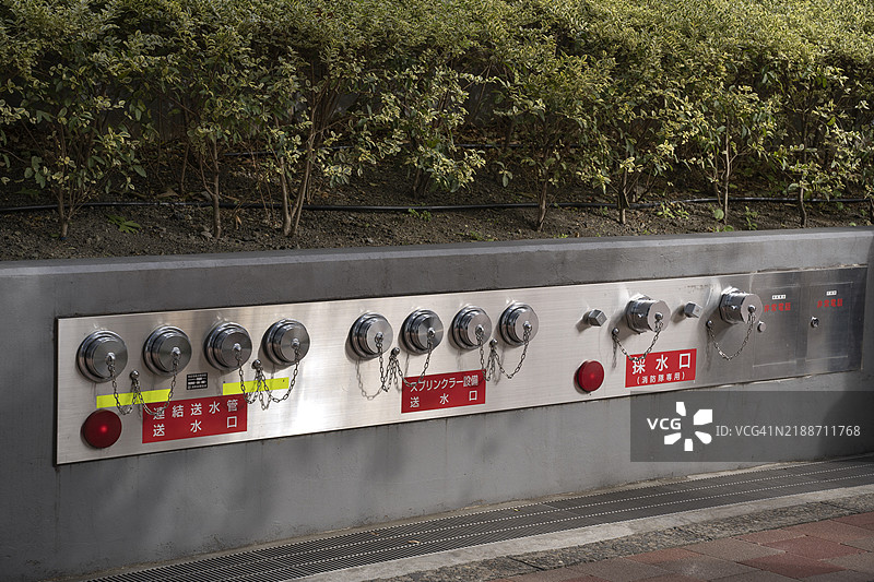 东京新宿市一栋建筑外的消防栓、消防水带和灭火器设备连接。图片素材