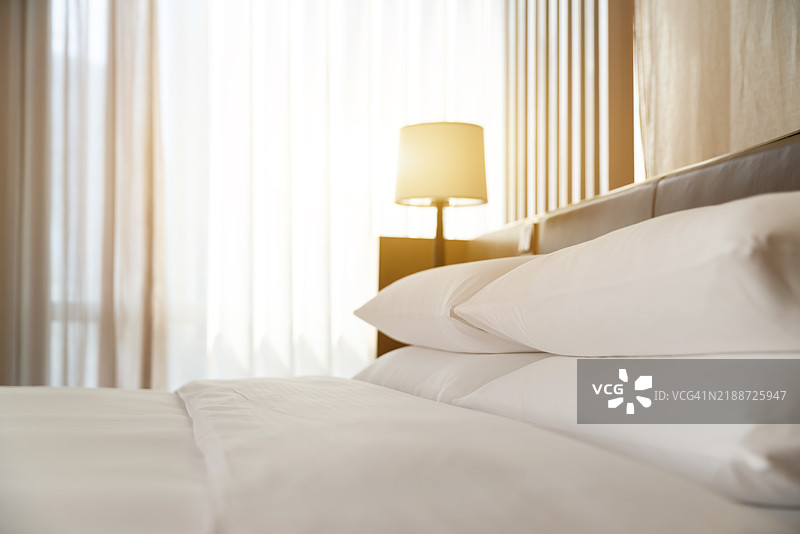 现代酒店中的舒适床铺。图片素材