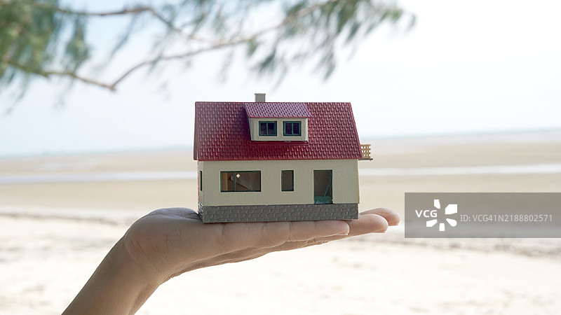 人手上的梦想海滩别墅概念图片素材