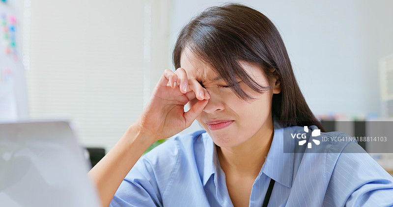 女性在工作中感到眼睛疼痛图片素材
