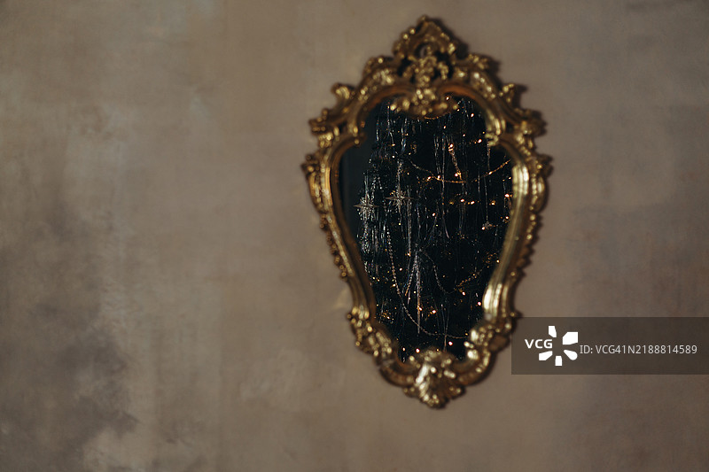 复古金色框架的镜子映照出圣诞树。图片素材