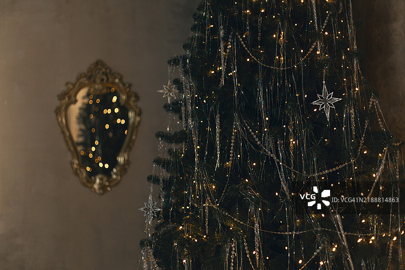 圣诞树和一面复古金色框镜子。图片素材