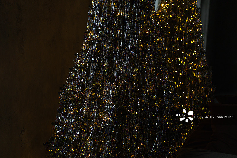 华丽的圣诞树在黑暗房间的镜子中倒影。图片素材