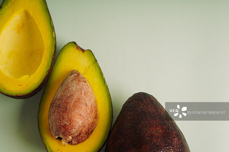 新鲜鳄梨特写，背景为柔和薄荷绿图片素材