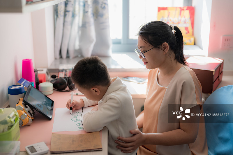 亚洲母亲陪伴儿子画画图片素材