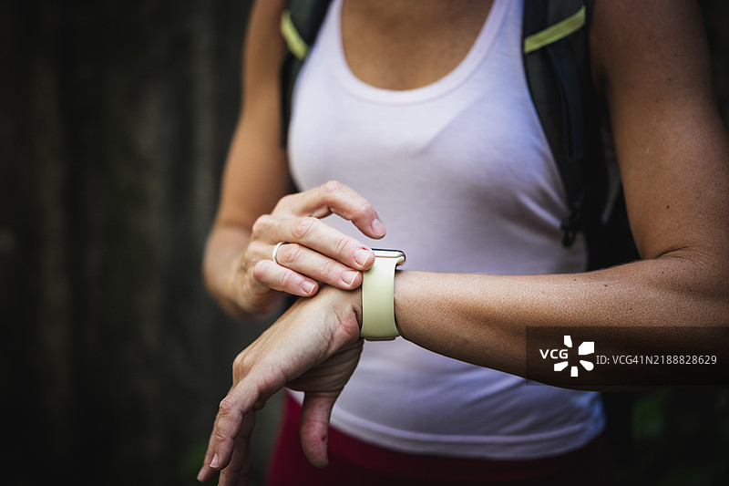 徒步旅行的女性在远足时使用智能手表图片素材