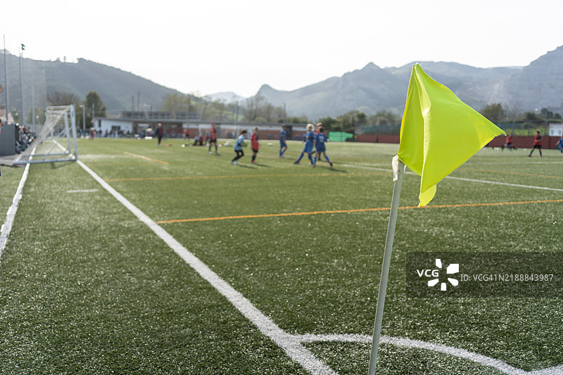 足球场上的黄色角旗，孩子们正在玩耍图片素材