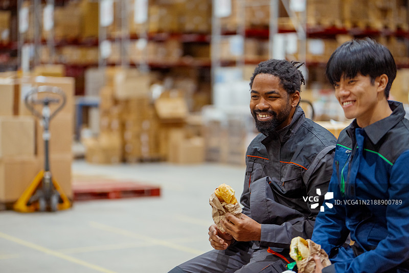 来自不同文化的仓库工人在仓库中享受休息时光图片素材