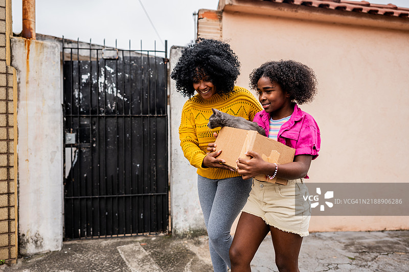 母女在城市中救助一只被遗弃的猫咪图片素材