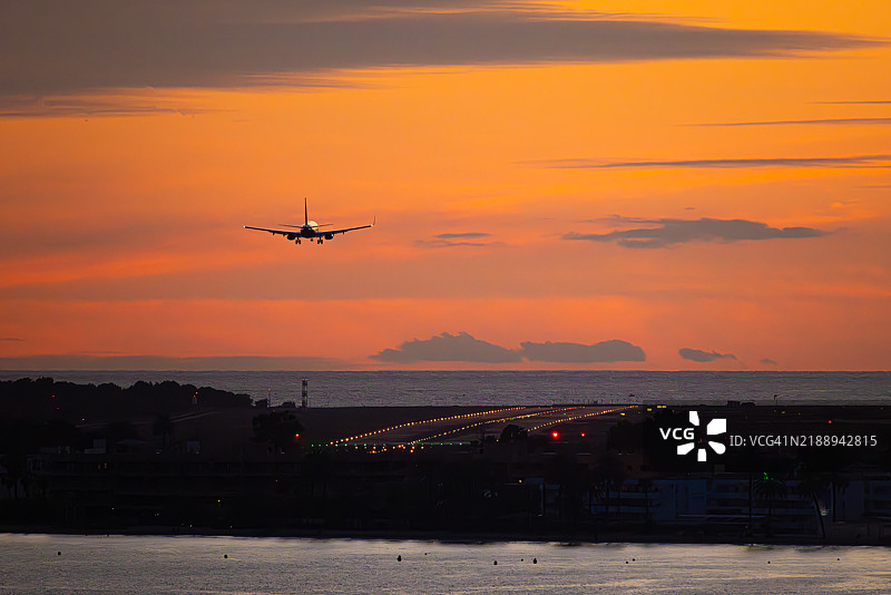 西班牙伊比萨机场日落时分的飞机降落图片素材