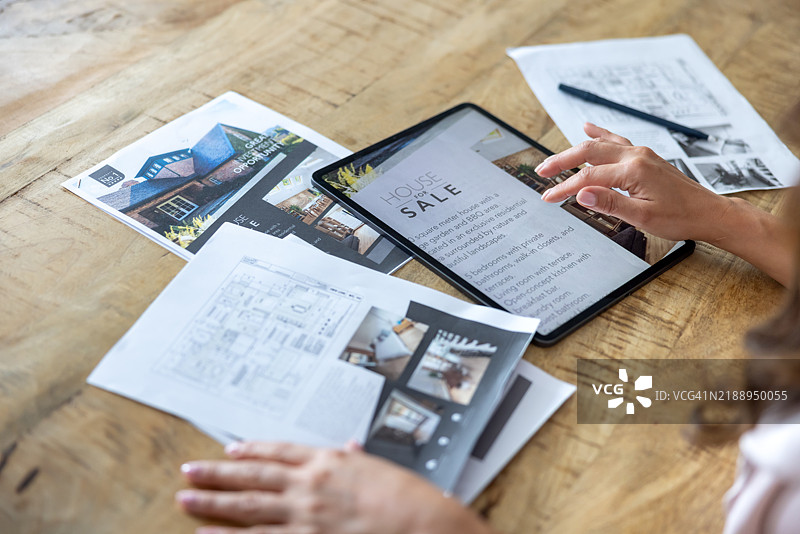 房地产经纪人在使用平板电脑在线列出房产图片素材