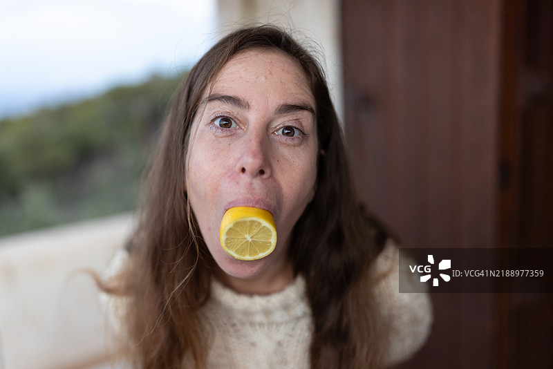 女人嘴里含着半个柠檬 – 股票照片图片素材