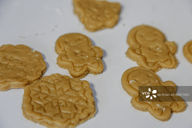 有趣的姜饼人和生面团雪花的形象。圣诞糕点。白色桌子。图片素材