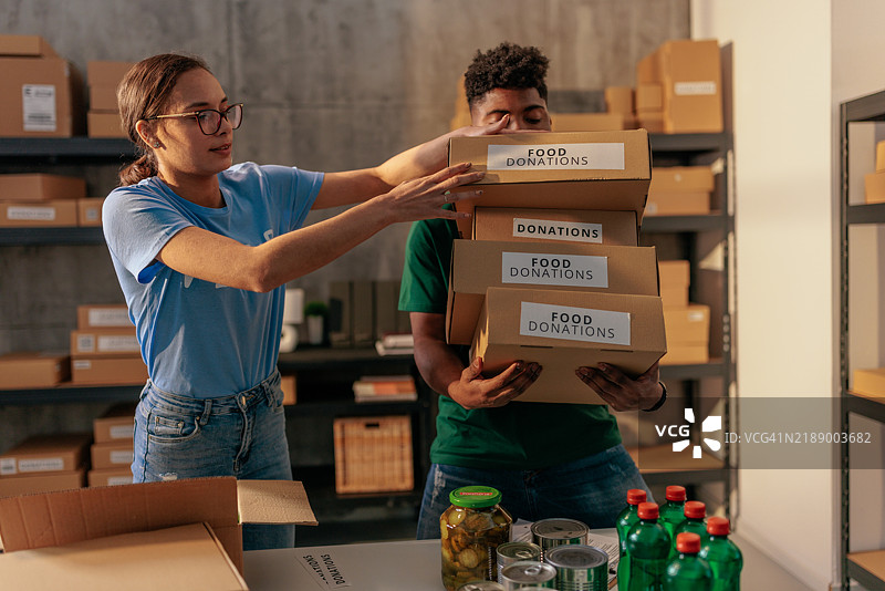 志愿者伸手去拿捐赠的食品箱图片素材