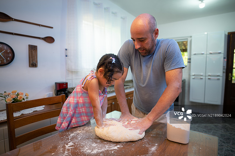父亲和女儿一起制作自制面包。图片素材