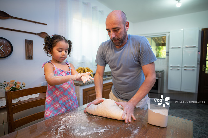 父亲和女儿一起制作自制面包。图片素材