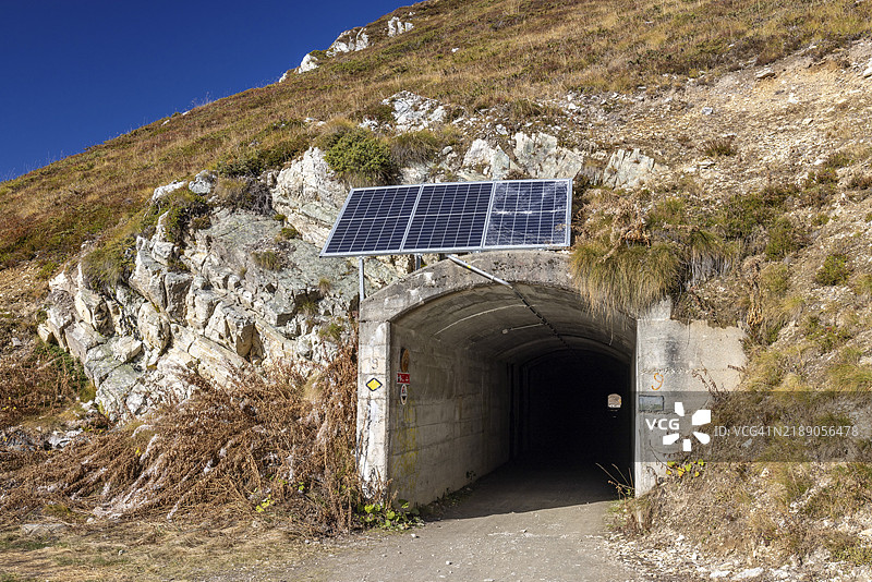 被落石毁坏的隧道入口，装有太阳能电池板，位于瑞士瓦莱州的韦尔比耶，心脏十字。图片素材