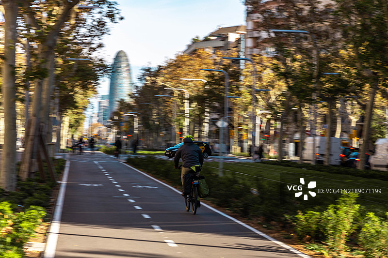 在巴塞罗那城市的宽阔绿道上，模糊的自行车运动。图片素材