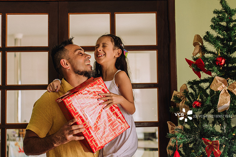 父亲和女儿通过赠送礼物庆祝圣诞节图片素材