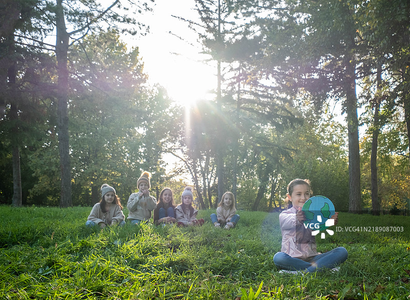 快乐的孩子们坐在草地上图片素材