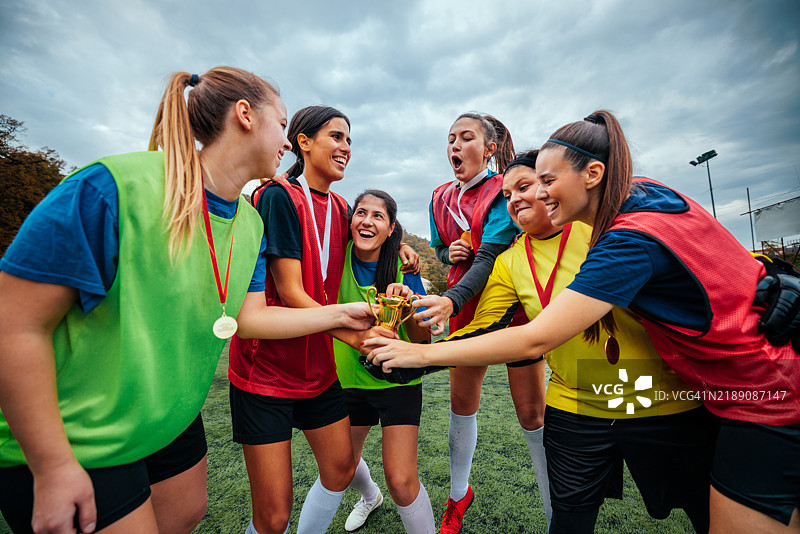 女子足球队与奖杯和奖牌。图片素材