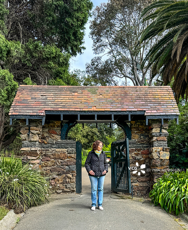 女性走过墨尔本皇家植物园的林荫门图片素材