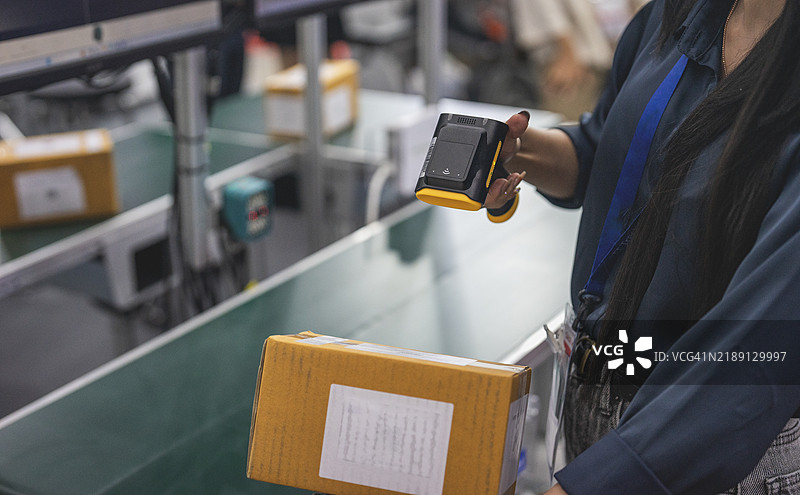 女性工作人员在仓库中扫描箱子图片素材