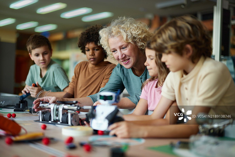 快乐的老师在实验室里帮助学生进行科学项目。图片素材