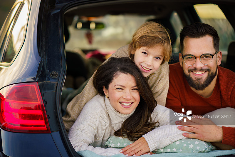 父母和他们的儿子在车后座享受休息时光图片素材